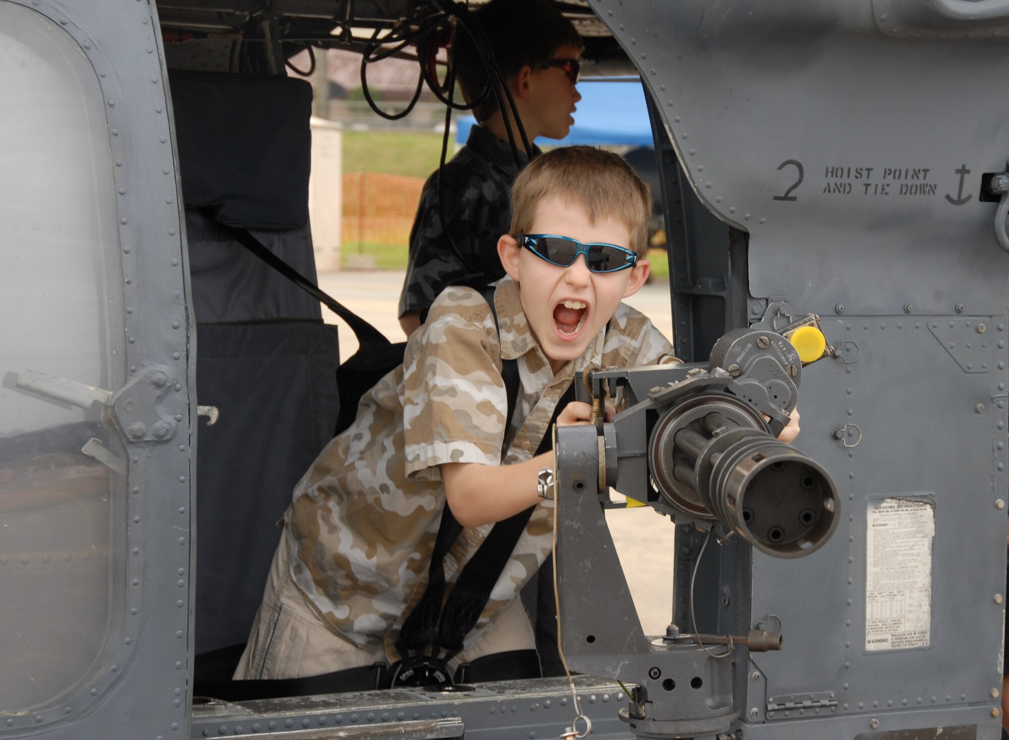OSAN AIR BASE, Republic of Korea --  Wyatt Kim, the 9-year-old son of Maj. Ian Kim, an HH60-G pilot, pretends to be an aerial gunner on a GAU-2 mini gun during Air Power Day on Oct. 6. (U.S. Air Force photo by Staff Sgt. Ronnie Hill)