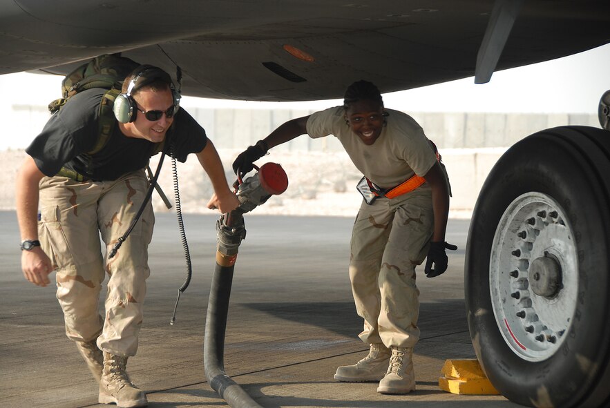 SOUTHWEST ASIA -- Staff Sgt. James Hansen, an aircraft maintainer with the 379th Expeditionary Aircraft Maintenance Squadron, and Airman 1st Class Janine Williamswood, a fuel specialist with the 379th Expeditionary Logistics Readiness, pull a fuel hose from under a B-1B Lancer after completing a 4,000 pound fuel “topoff” of the aircraft Sept. 29. Sergeant Hansen is deployed to Southwest Asia from Dyess Air Force Base, Texas and Airman Williamswood is deployed from RAF Mildenhall, UK. (U.S. Air Force photo/Staff Sgt. Douglas Olsen)