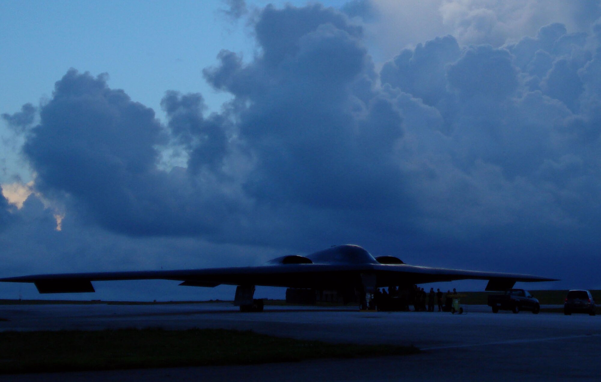 The B-2 Spirits from Whiteman Air Force Base, Mo., arrive here under cloudy skies and a rainy evening 7 Oct. This stealth bomber is parked on the tarmac at Andersen Air Force Base and is immediately serviced by maintenance crews after its arrival. The Spirit is a two-person aircraft and is equipped with stealth technology. These airframes are replacing the B-52 Stratofortresses deployed here from Barksdale Air Force Base, La. (Air Force Photo/Capt. Bryan Florio)

