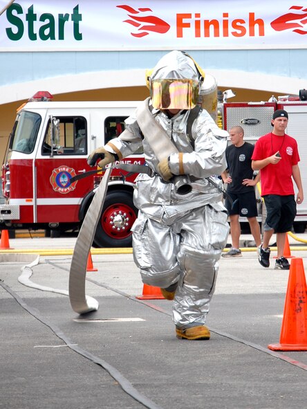 ANDERSEN AFB, GUAM---Senior Airman Christopher Palkowetz, 36th Civil Engineering Squadron, runs with a hose, October 6, 2007, during the 2nd Annual Island-Wide Firefighter Muster that was held at the Agana Shopping Center in conjuction with Fire Prevention Week.  Andersen's Firefighters placed second overall for both days that the event was held.(U.S. Air Force photo by Senior Airman Miranda Moorer)(RELEASED)                                     