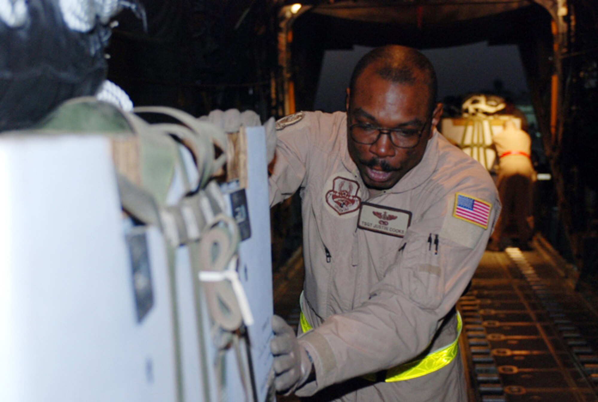 Tech. Sgt. Justin Cooks loads a pallet of supplies onto a C-130 Hercules at Balad Air Base, Iraq, for an air drop mission to Army ground troops at a forward-deployed location in Southwest Iraq.  Sergeant Cooks is a loadmaster with the 777th Expeditionary Airlift Squadron. (U.S. Army photo/Sgt. Jasmine Chopra)