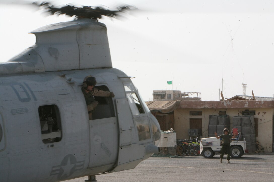 AL TAQADDUM, Iraq- A flightline Marine directs a Marine Medium Helicopter Squadron 268 CH-46E as it taxis down the runway, Oct. 9.  The 'Red Dragons' conduct general and assault support missions as well as escorting VIPs and deliver injured or recovering personnel to the necessary treatment facilities.