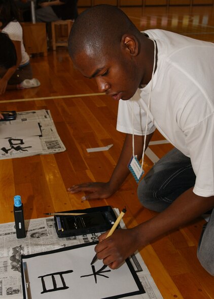 FUSSA, Japan - SrA Michael Mitchell, from the 374th Maintenance Squadron, writes Kanji during the Fussa Elementary Exchange program on October 4, 2007. Volunteers from Yokota Air Base, Japan visited the Fussa Fourth Elementary School and were given the chance to interact with a group of 6th graders and learn about their culture through various workshops set up by the students. (U.S. Air Force photo by Airman First Class Jonathan Fowler)