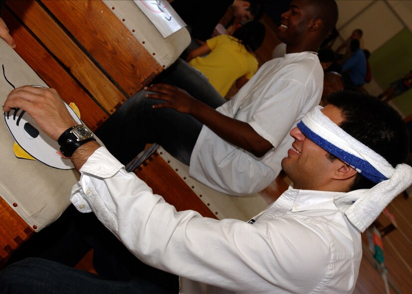 FUSSA, Japan - Staff Sergeant Anthony Ruy, from the 374th Maintenance Squadron, places the eyebrows on a paper face during the Fussa Elementary Exchange program on October 4, 2007. Volunteers from Yokota Air Base, Japan visited the Fussa Fourth Elementary School and were given the chance to interact with a group of 6th graders and learn about their culture through various workshops set up by the students. (U.S. Air Force photo by Airman First Class Jonathan Fowler)