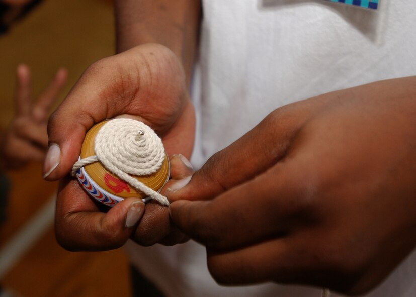 FUSSA, Japan - Senior Airman Michael Mitchell, from the 374th Maintenance Squadron, wraps the string around a top during the Fussa Elementary Exchange program on October 4, 2007. Volunteers from Yokota Air Base, Japan visited the Fussa Fourth Elementary School and were given the chance to interact with a group of 6th graders and learn about their culture through various workshops set up by the students. (U.S. Air Force photo by Airman First Class Jonathan Fowler)