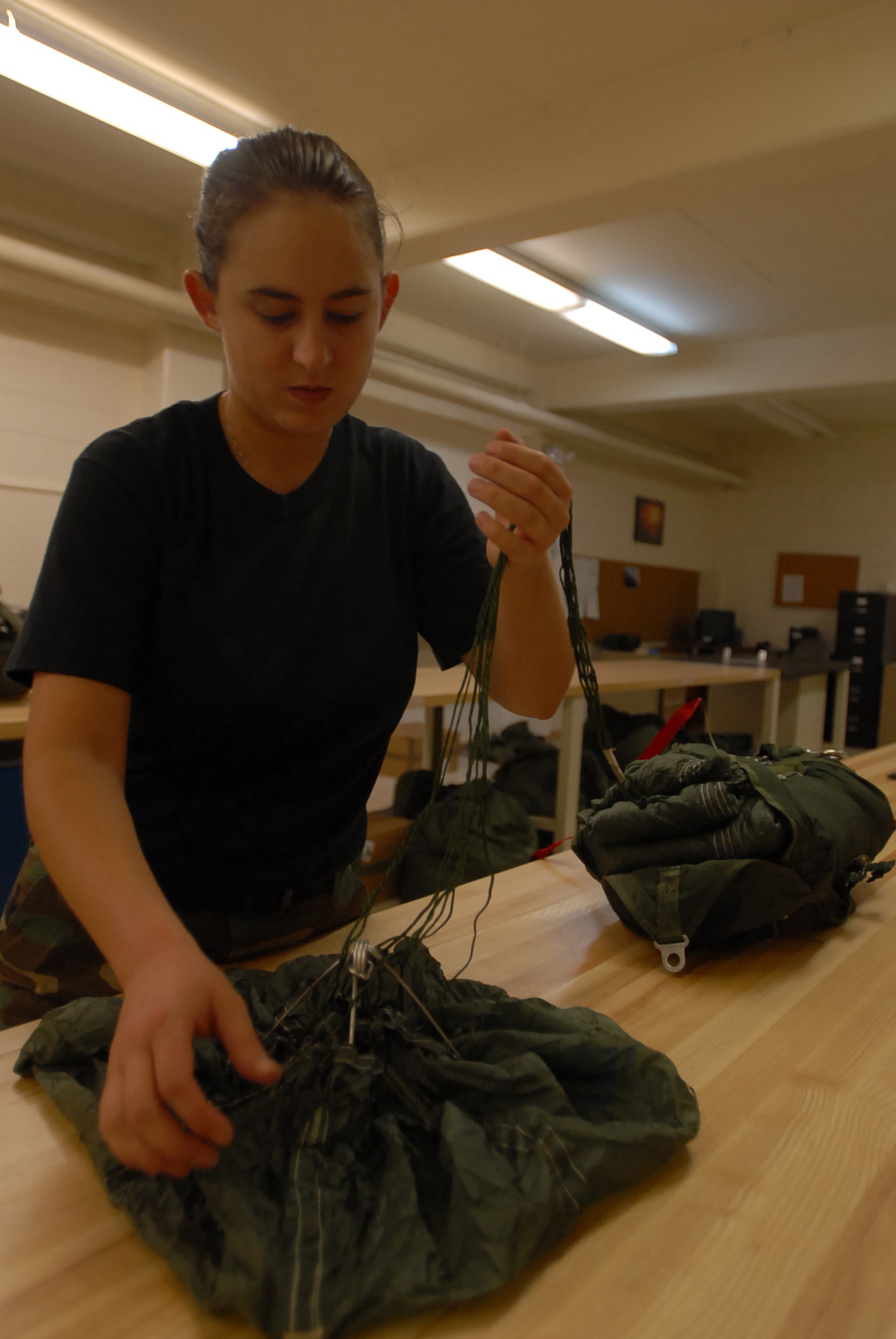 Staff Sgt. Amanda Schmidt folds a chest reserve parachute at Kadena Air Base, Japan,  Oct. 9, 2007 . The parachute is used in case someone has to make an emergency exit from an aircraft. Sergeant Schmidt works with aircrew flight equipment in the 18th Operations Support Squadron.  (U.S. Air Force photo/Senior Airman Darnell T. Cannady)