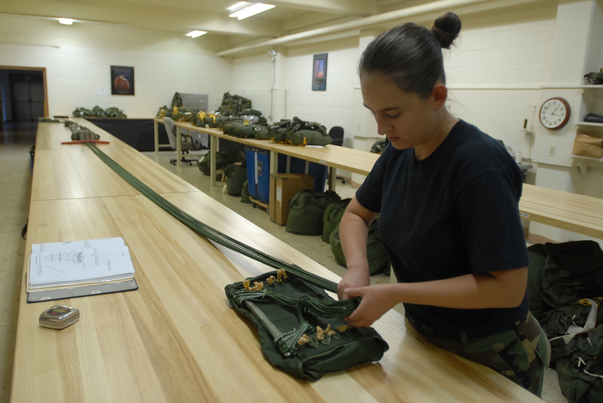 Staff Sgt. Amanda Schmidt folds a chest reserve parachuteat Kadena Air Base, Japan,  Oct. 9, 2007 . The parachute is used in case someone has to make an emergency exit from an aircraft. Sergeant Schmidt works with aircrew flight equipment in the 18th Operations Support Squadron. (U.S. Air Force photo/Senior Airman Darnell T. Cannady) 