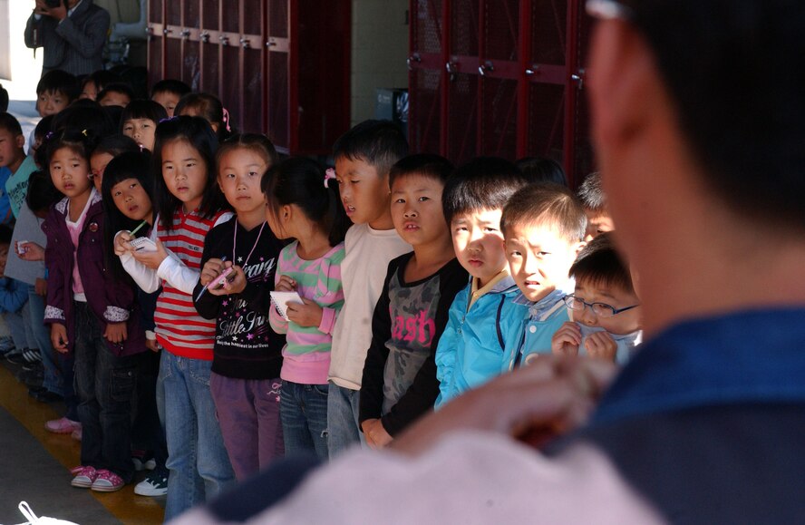 KUNSAN AIR BASE, South Korea -- Kim Ki Song, 8th Civil Engineer Squadron firefighter, explains the firefighter’s mission to local Korean students during their visit to the fire department here Oct. 9.  The children were from several schools throughout Gunsan City, South Korea. They toured the base fire station as part of Fire Prevention Week. (U.S. Air Force photo/Senior Airman Steven R. Doty)                    