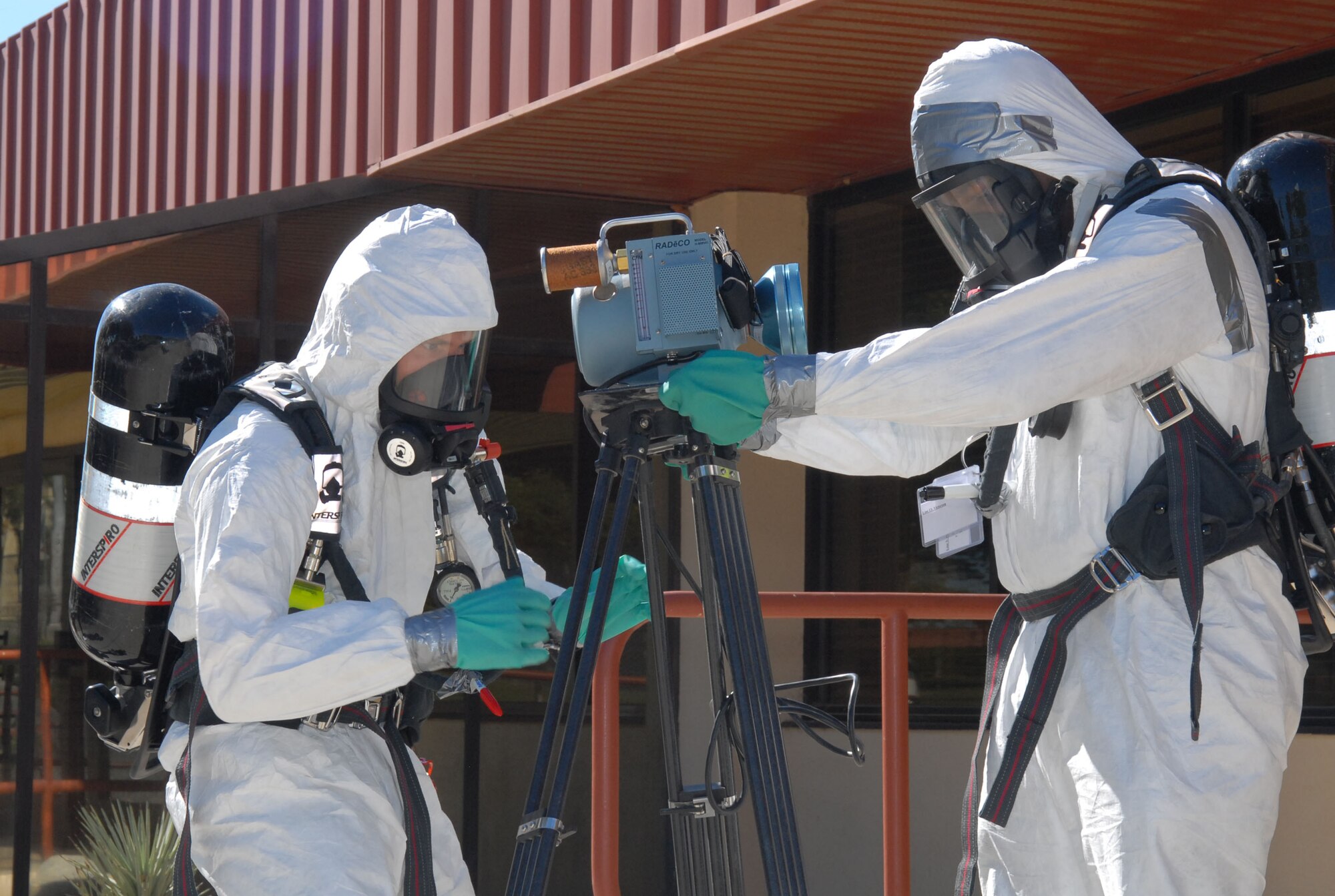 Senior Airman Shane Polk (right) and Airman 1st Class Andrew Croop, 95th Aerospace Medicine Squadron bioenvironmental engineer journeymen, set up the high-volume air sampler at the Joshua Tree Inn Dining Facility here Oct. 3. This was part of the Air Force Materiel Command's CBRN Challenge. (Photo by Senior Airman Julius Delos Reyes)