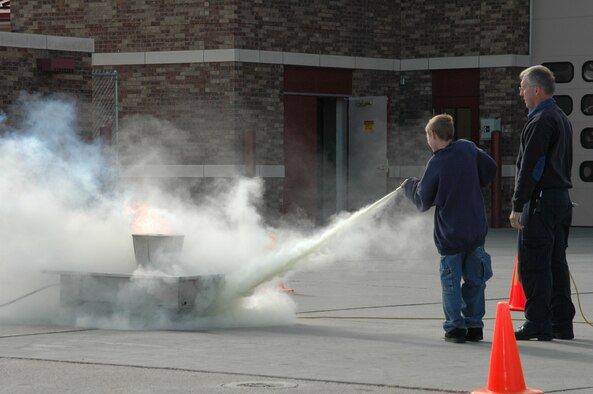 Children are coached on how to effectivly use a fire extinguisher during an open house at the fire department Oct. 6. The open house was preceeded by a Fire Prevention Week Parade. This year's theme is Practice your Escape Plan.
(U.S. Air Force photo/Airman 1st Class Kimberly Moore Limrick)