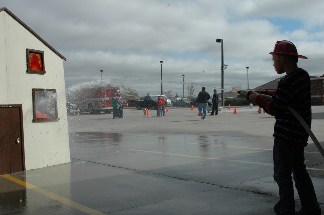 Children demonstrate their aim-and-filre skills by spraying "fire flames" out of the windows of a simulated burning house during an open house at the fire department Oct. 6. The open house was preceeded by a Fire Prevention Week Parade. This year's theme is Practice your Escape Plan.
(U.S. Air Force photo/Airman 1st Class Kimberly Moore Limrick)