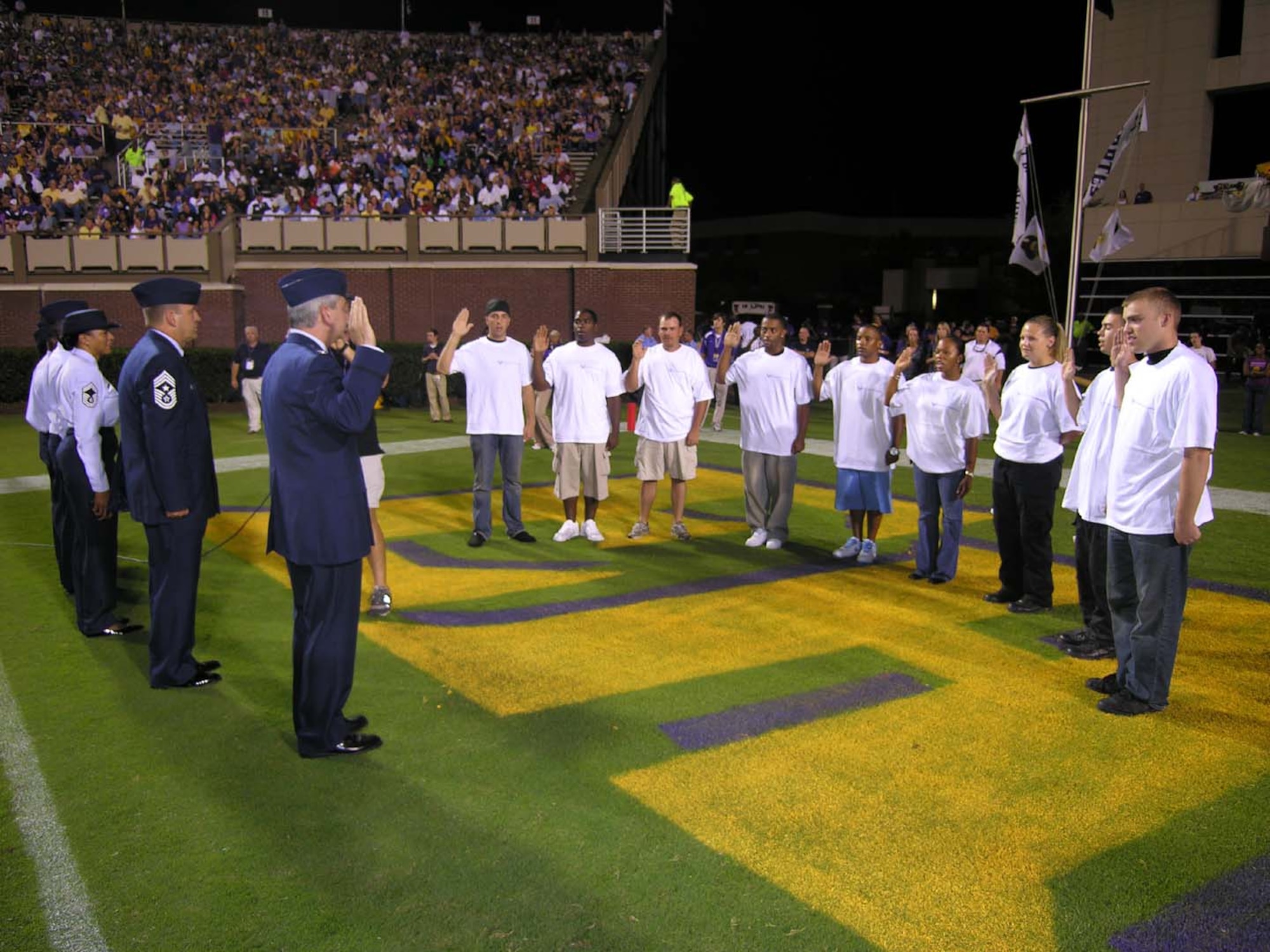 SEYMOUR JOHNSON AIR FORCE BASE, N.C. -- Col. Fritz Linsenmeyer (front left) swears in nine new recruits to the 916th Air Refueling Wing during the East Carolina University football game. The mass enlistment was part of a nation-wide Air Force Reserve Command Recruiting initiative held Oct. 1-14. More than 42,000 fans were in attendance at the game against the University of Central Florida and witnessed the oath of enlistment being administered. Col. Linsenmeyer is the wing commander of the 916th Air Refueling Wing. He was joined on the field by Command Chief Master Sgt. Boltinhouse, a current student at ECU and the recruiters.