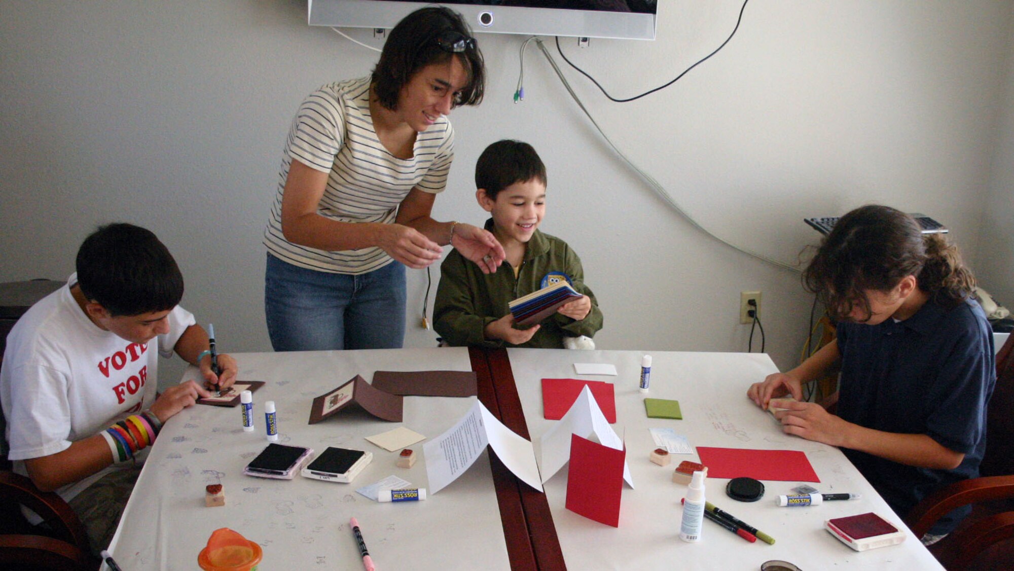 LAUGHLIN AIR FORCE BASE, Texas -- Loren Simmons and three children, Patrick, 12, Nathaniel, 6, and Brenna Simmons, 11, make holiday cards for their deployed father, Maj. Matthew Simmons, 47th Operations Group, at Su Casa recently . (U.S. Air Force photo by Tech. Sgt. Joel Langton)
