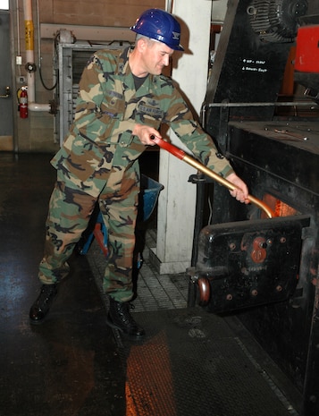 Col. Paul Gydesen, 341st Space Wing vice commander, shovels coal into the coal-fired heat plant at Malmstrom following his first tour of the facility Oct. 3. The plant is closed during summer months and re-opens in the fall to heat the buildings on Malmstrom with hot water. (U.S. Air Force photo/Airman 1st Class DIllon White) 