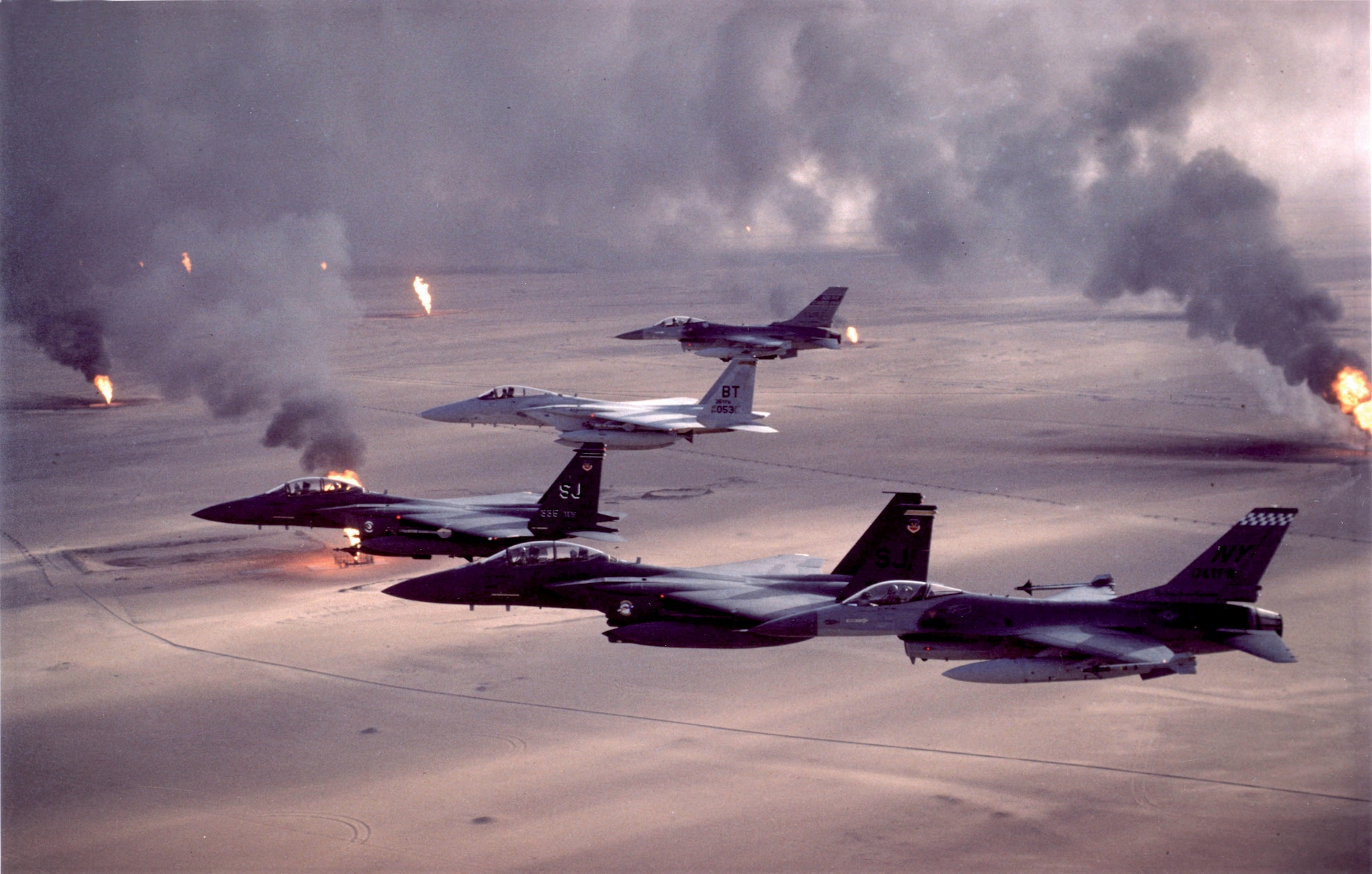jets flying over burning oil fields