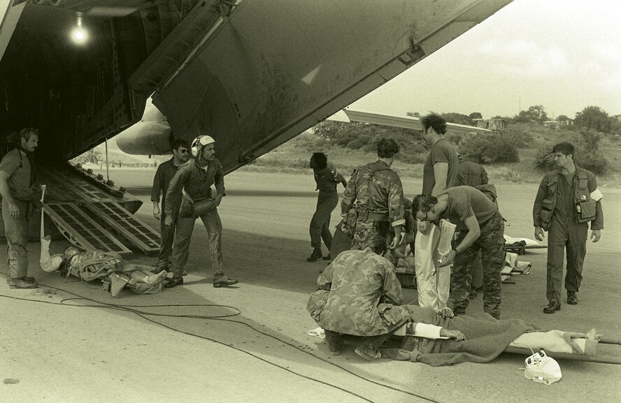A wounded soldier is treated by U.S. military personnel before being placed aboard a C-141B Starlifter aircraft for medical evacuation during Operation Urgent Fury in Grenada, which occurred Oct. 25 to Nov. 3, 1983.
