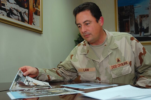 SOUTHWEST ASIA -- Mr. Peter Law, 386th Air Expeditionary Wing historian, looks through old photographs that will be archived here Oct. 9.  Mr. Law is deployed from Randolph Air Force Base, Texas.  (U.S. Air Force photo by Staff Sgt. Tia Schroeder)