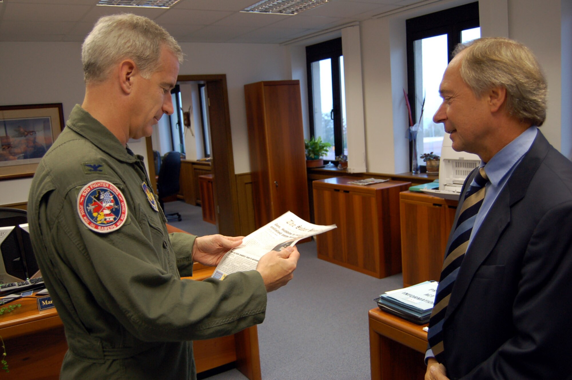 SPANGDAHLEM AIR BASE, Germany – Col. Thomas Feldhausen, 52nd Fighter Wing vice commander, thanks John Thompson, The Saber Herald publisher, for his work to bring a newspaper back to Spangdahlem Air Base Oct. 5. The Saber Herald is published by AdvantiPro, who consolidates information from Spangdahlem Air Base and other Air Force Web pages into the paper. (U.S. Air Force photo/Capt. Kevin Coffman)