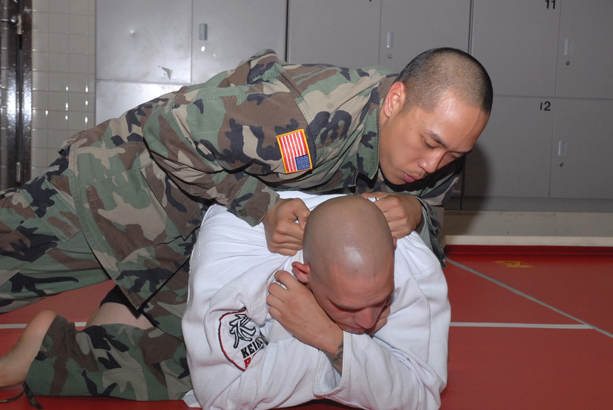 OSAN AIR BASE, Republic of Korea --  Spc. Lawrence Ranches leaps over Sgt. Jared Hinsley in an effort to ensure Sergeant Hinsley has no way of escaping from his grip by jamming his leg into Sergeant Hinsley’s side. The combatives class, taught by Soldiers with Headquarters and Headquarters  Batter, 35th Air Defense Artillery, is held every Tuesday and Thursday from 7-9 p.m. in the old firehouse building here. (U.S. Army photo by Pfc. Gretchen N. Goodrich)