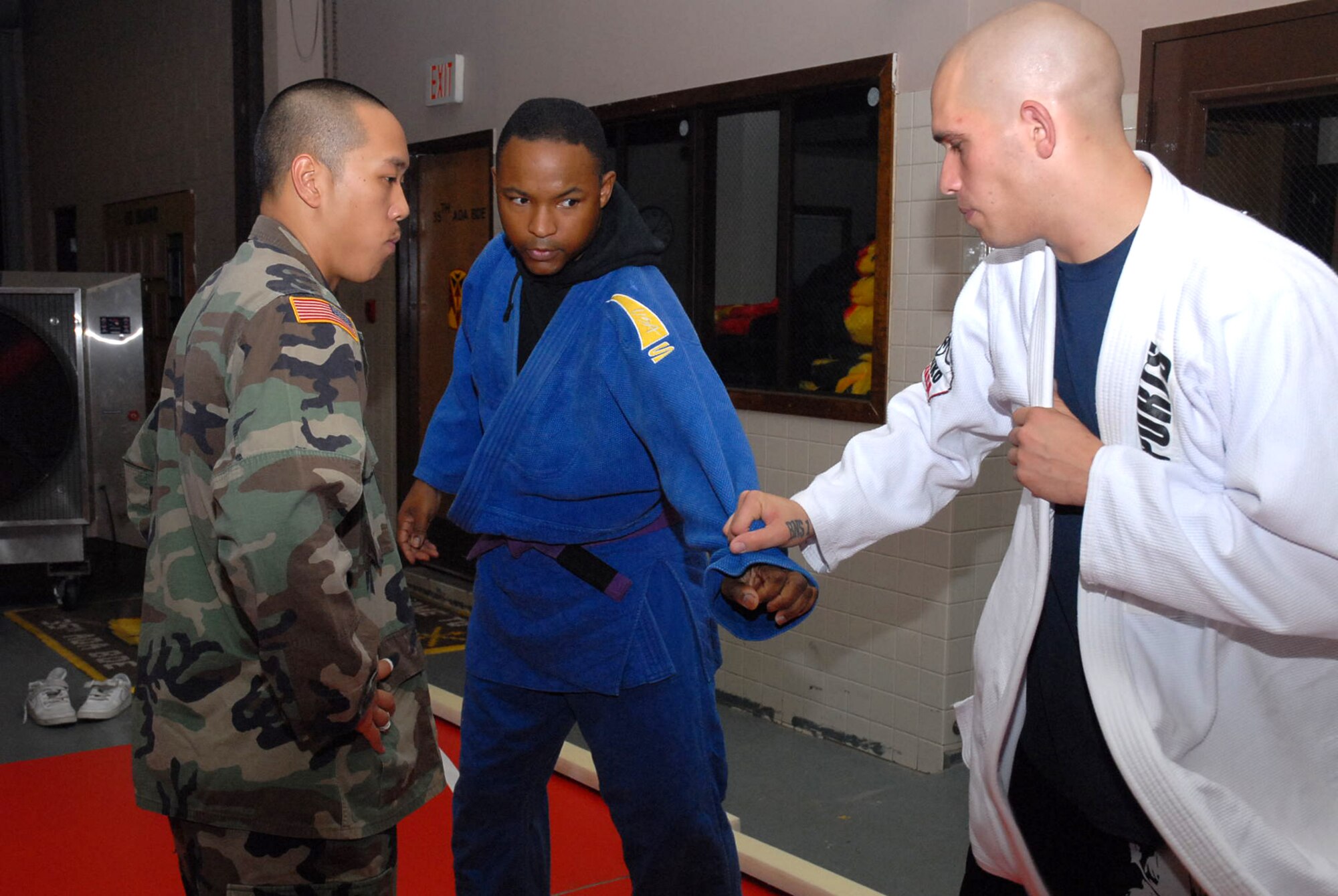 OSAN AIR BASE, Republic of Korea --  Spc. Lawrence Ranches instructs Master Sgt. Xavier Whitehead and Sgt. Jared Hinsley in conducting blocking grabs during the combatives class here. The class is held every Tuesday and Thursday from 7-9 p.m. in the old firehouse building here. (U.S. Army photo by Pfc. Gretchen N. Goodrich)