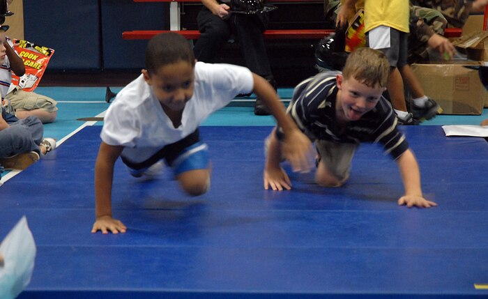 Brett Fischer, 6, son of Staff Sgt. Veronica Fischer, and Andrew Marabella, 5, son of Staff Sgt. Andrew Marabella, practice how to stay low to the ground to avoid smoke inhalation during an escape from fire at the Youth Programs Center Tuesday. (U.S. Air Force photo/Airman Melissa White)