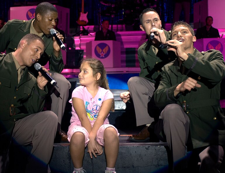 Tops in Blue Airmen serenade seven-year-old Hayley Godfrey of Acworth, Ga., during an Air Force musical tribute Oct. 9 in Mableton, Ga. Hayley is the daughter of Chief Master Sgt. Dallas Godfrey stationed at Dobbins Air Reserve Base, Ga. Tops In Blue was in Georgia as part of Air Force Week Atlanta honoring 60 years of Air Force history.  (U.S. Air Force photo/Staff Sgt. Bennie J. Davis III)