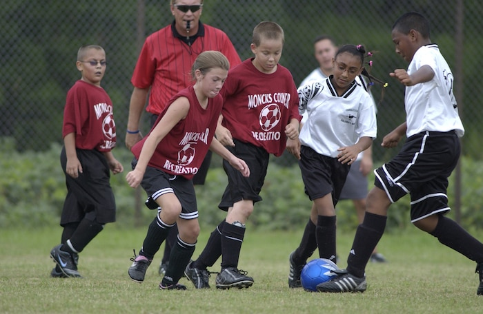 Tylil Early, 11, and his sister, Alyssa Early, 9, children of Master Sgt. Sean Early, try to get the soccer ball past members of a Moncks Corner soccer team during their game Saturday on Charleston AFB. (U.S. Air Force photo/Tech. Sgt. Paul Kilgallon)   
