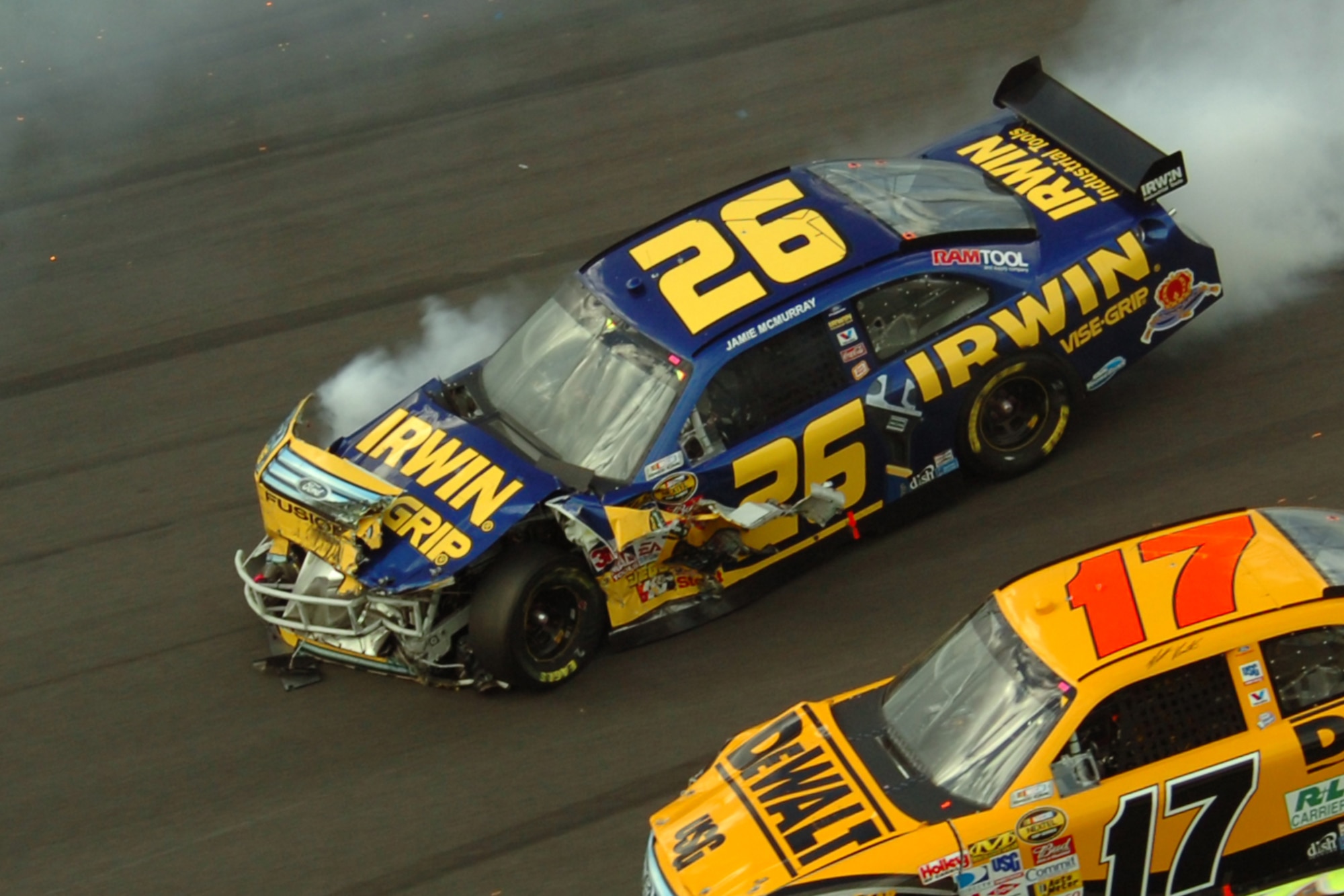 TALLADEGA, Ala. -- Jamie McMurray, No. 26 Ford Fusion, slides down the high banks after hitting the wall in a 11-car chain reaction crash on Turn 4 of Lap 144. Fire safety crews all around the track responded immediately to the crash. On pit road, John Piccuito, J.R. Suddarth and Tech. Sgt. Jimmy Reed, Eglin Air Force Base firefighters, are among a group of firefighters from all over the country that go to the spring and fall Talladega NASCAR races to make sure the drivers and race teams are safe. They provided safety for the Friday night Automobile Racing Club of America RE/MAX Series race, the NASCAR Craftsman Truck Series race on Saturday and the NASCAR Nextel Cup Series race on Sunday. (U.S. Air Force photo by Staff Sgt. Mike Meares)