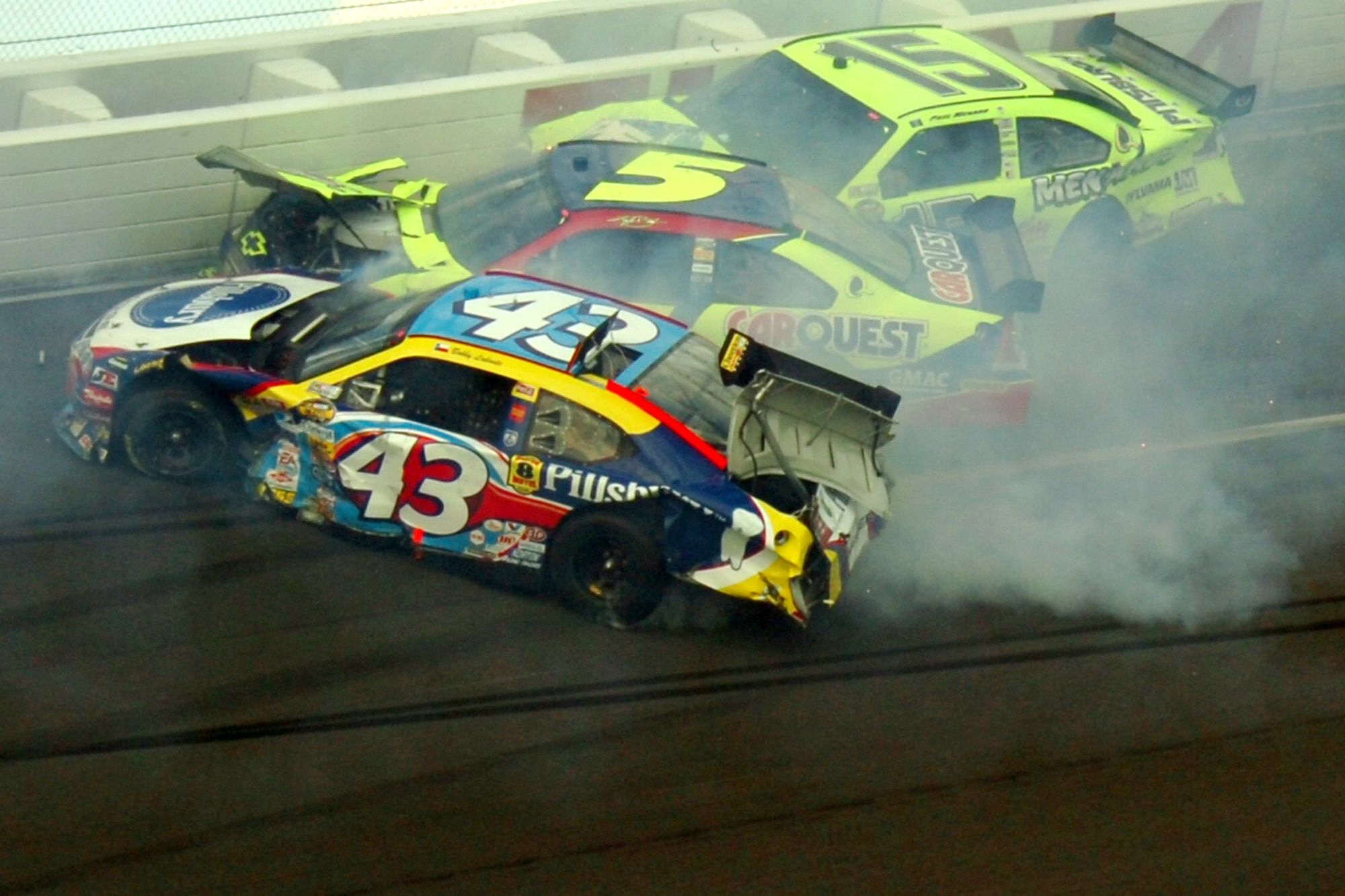 TALLADEGA, Ala. -- Bobby Labonte, No. 43 car, was in the fifth position when he suddenly lost control in Turn 4 of Lap 144, starting a chain reaction that caused the infamous "Big One." It left 10 other drivers in the wrong place at the wrong time. On pit road, John Piccuito, J.R. Suddarth and Tech. Sgt. Jimmy Reed, Eglin Air Force Base firefighters, are among a group of firefighters from all over the country that go to the spring and fall Talladega NASCAR races to make sure the drivers and race teams are safe. They provided safety for the Friday night Automobile Racing Club of America RE/MAX Series race, the NASCAR Craftsman Truck Series race on Saturday and the NASCAR Nextel Cup Series race on Sunday. (U.S. Air Force photo by Staff Sgt. Mike Meares)