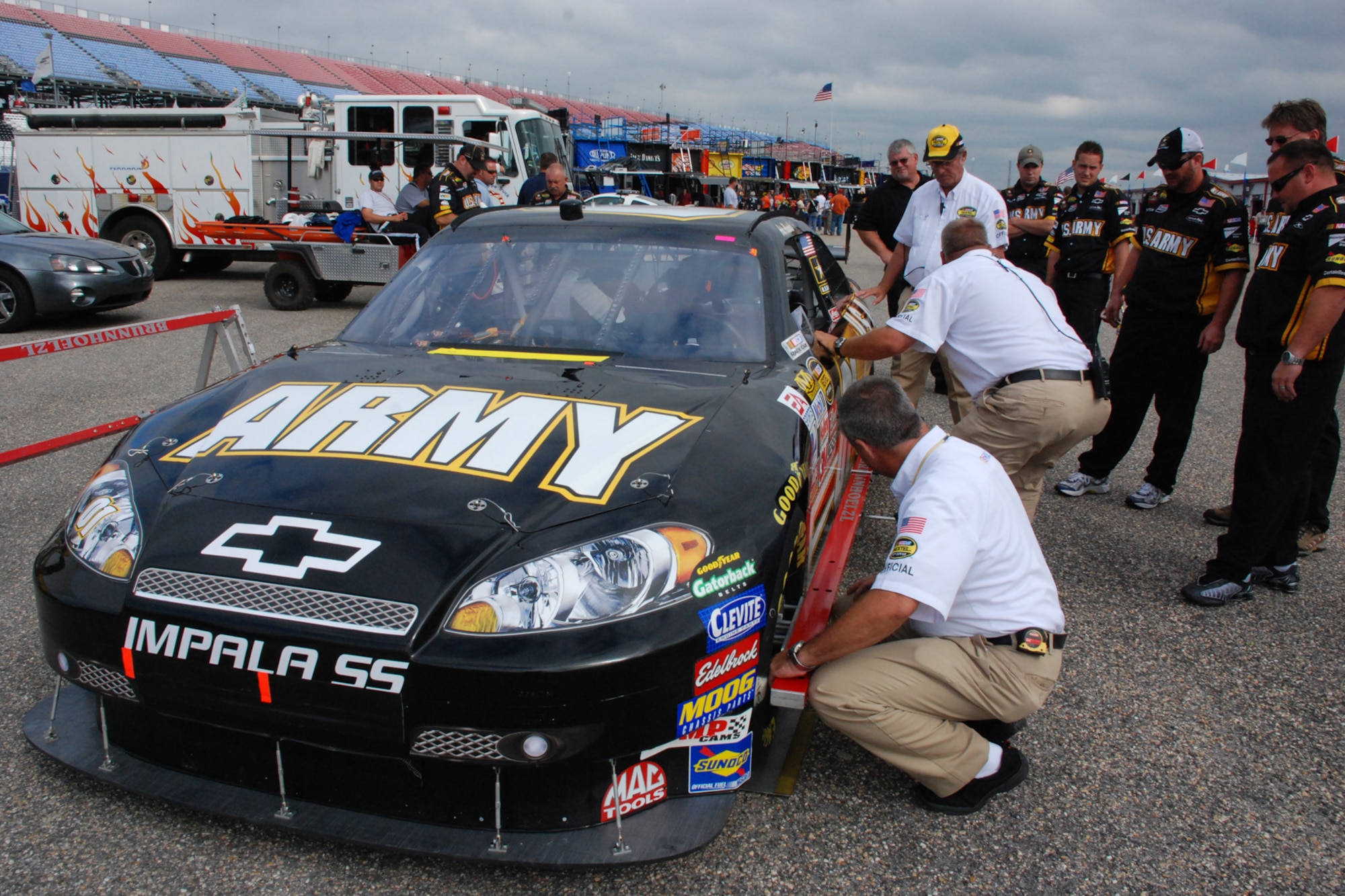 TALLADEGA, Ala. -- The No. 01 Army car gets inspected in the garage Oct. 6 while one of the fire trucks and a three-man crew sits in the background watching the action in the garage. John Piccuito, J.R. Suddarth and Tech. Sgt. Jimmy Reed, Eglin Air Force Base firefighters, are among a group of firefighters from all over the country that go to the spring and fall Talladega NASCAR races to make sure the drivers and race teams are safe. They provided safety for the Friday night Automobile Racing Club of America RE/MAX Series race, the NASCAR Craftsman Truck Series race on Saturday and the NASCAR Nextel Cup Series race on Sunday. (U.S. Air Force photo by Staff Sgt. Mike Meares)