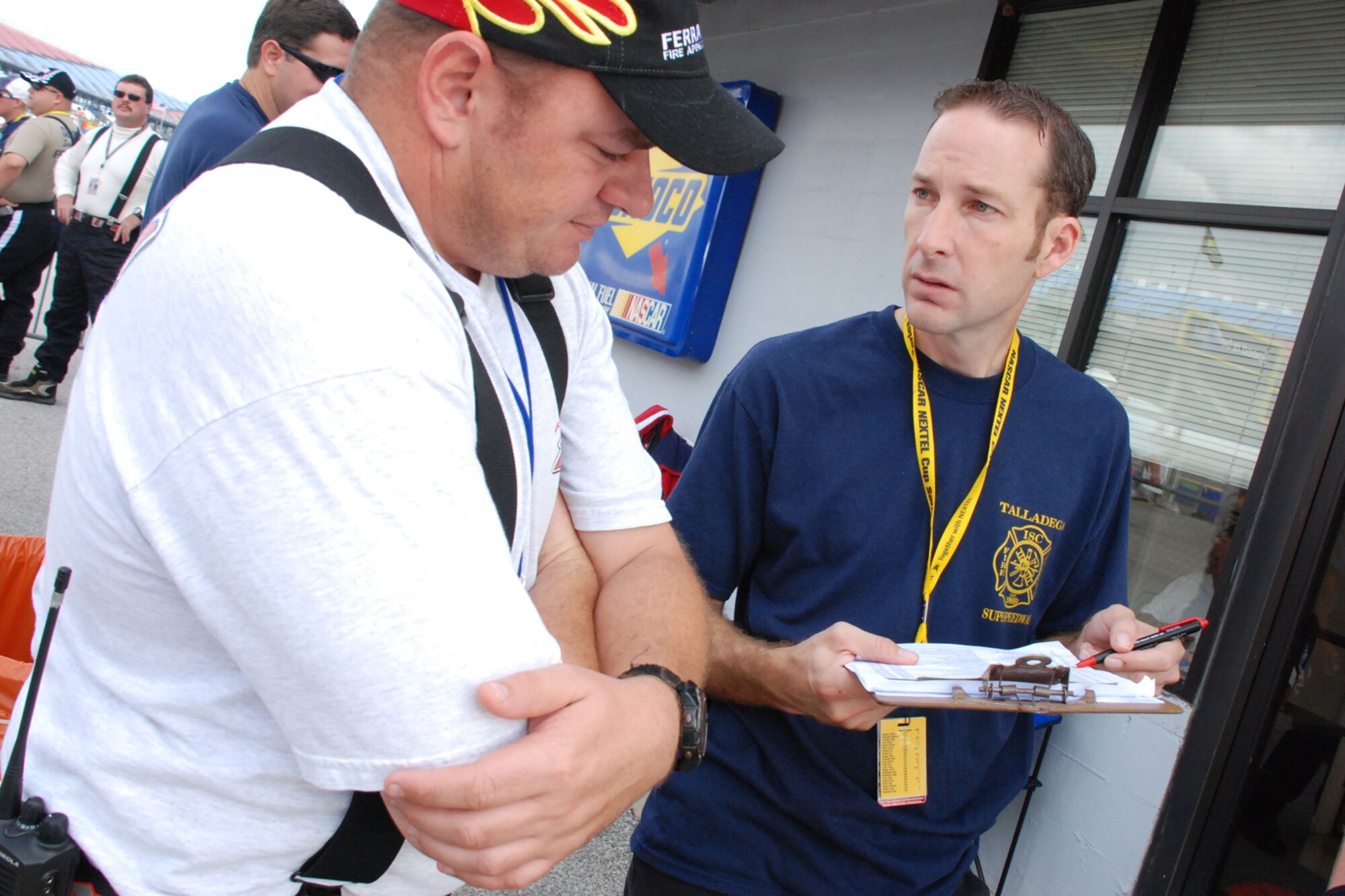 TALLADEGA, Ala. -- Tech. Sgt. Jimmy Reed and J.R. Suddarth go over the pit assignments before the start of the NASCAR Craftsman Truck Series race Oct. 6. John Piccuito, Mr. Suddarth and Sergeant Reed, Eglin Air Force Base firefighters, are among a group of firefighters from all over the country that go to the spring and fall Talladega NASCAR races to make sure the drivers and race teams are safe. They provided safety for the Friday night Automobile Racing Club of America RE/MAX Series race, the NASCAR Craftsman Truck Series race on Saturday and the NASCAR Nextel Cup Series race on Sunday. (U.S. Air Force photo by Staff Sgt. Mike Meares)
