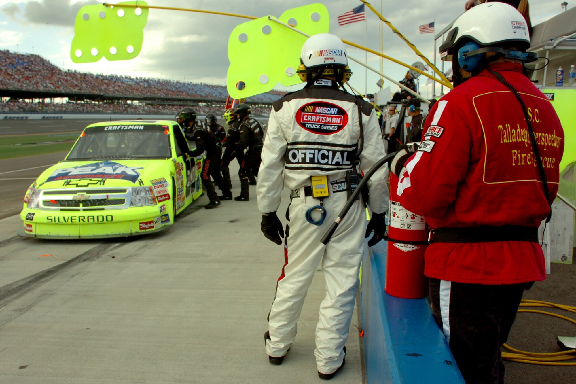TALLADEGA, Ala. -- Tech. Sgt. Jimmy Reed, Eglin Air Force Base, Fla., firefighter and Air Force reservist at Keesler AFB, Miss., stands watch over the action in the pits as the No. 88 team performs a quick gas and go pit stop Oct. 6 during the NASCAR Craftsman Truck Series race. John Piccuito, J.R. Suddarth and Sergeant Reed, Eglin Air Force Base firefighters, are among a group of firefighters from all over the country that go to the spring and fall Talladega NASCAR races to make sure the drivers and race teams are safe. They provided safety for the Friday night Automobile Racing Club of America RE/MAX Series race, the NASCAR Craftsman Truck Series race on Saturday and the NASCAR Nextel Cup Series race on Sunday. (U.S. Air Force photo by Staff Sgt. Mike Meares)