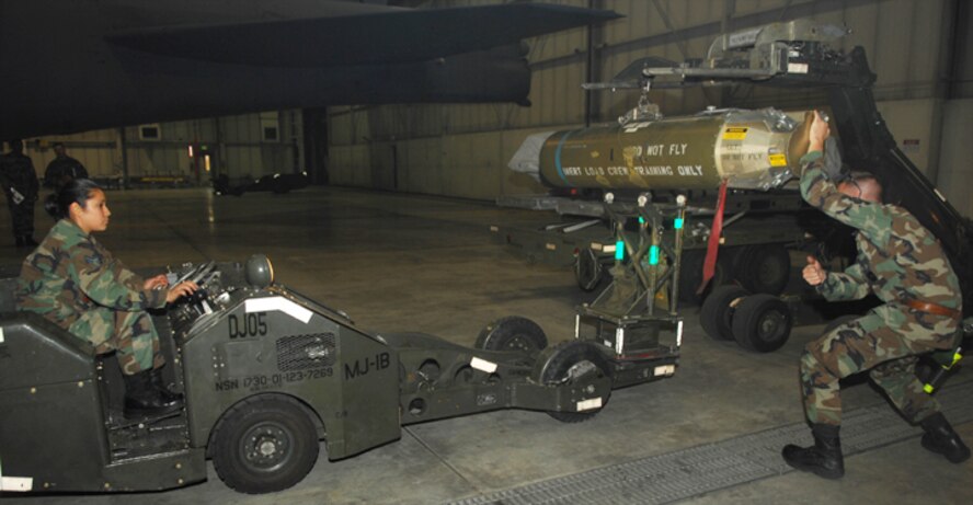 MINOT AIR FORCE BASE N.D. -- Staff Sgt. Troy Becker, 5th Aircraft Maintenance Squadron weapons loader (right), guides Airman 1st Class Rosa Phillips, also a 5th AMXS weapons loader, as she raises the lift on a support vehicle for transporting a cluster bomb unit to a B-52H Stratofortress during a weapons loading competition Oct. 5. Load crews consist of four-man teams, which are responsible for loading weapons onto aircraft. Each load crew is graded monthly on how well they load different types of munitions. (U.S. Air Force photo by Airman First Class Sharida Bishop)