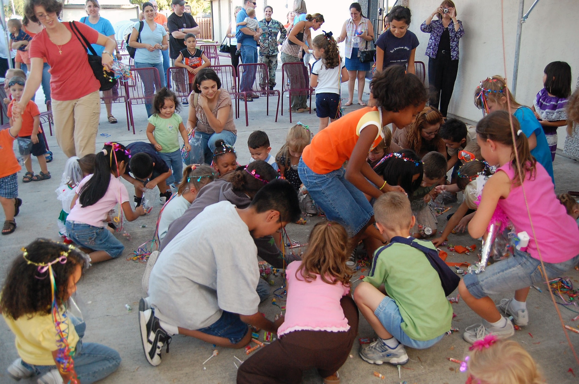 LAUGHLIN AIR FORCE BASE, Texas -- A swarm of children rushed to collect candy when the piñata was broken on the patio of Club Amistad during the Children's Fiesta October 4. By reading books and making crafts, the children were able to learn more about the Hispanic culture and why they do certain things. The Children's Fiesta was held on behalf of October being Hispanic Heritage month. (U.S. Air Force photo by Airman Sara Csurilla)