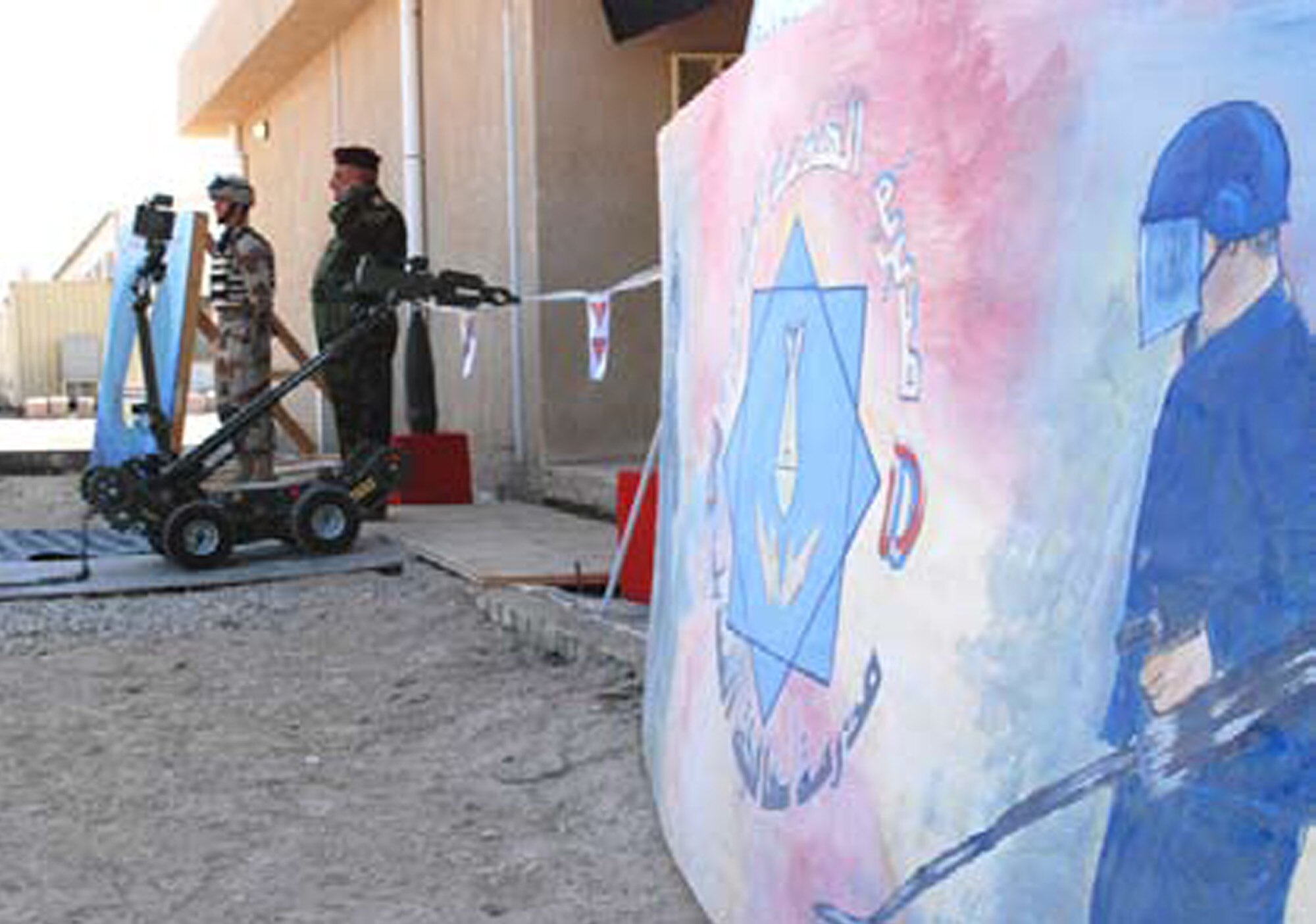 BESMAYA, Iraq -- The Mini-Andros II robot, controlled by the school’s faculty, cuts the ceremonial ribbon, marking the official opening of the school. The robot is the primary tool used by Iraqi forces for improvised explosive device detection and removal. (U.S. Air Force photo / Senior Airman Christie Putz)