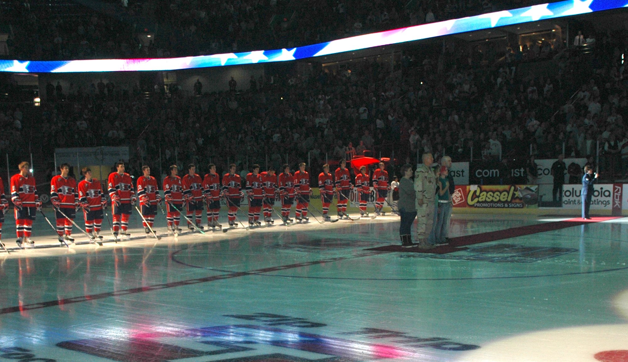 SPOKANE, Wash. – Standing with his family, Tech. Sgt. David Robinson, 92nd Aircraft Maintenance Squadron, stands at attention while Staff Sgt. Connie Bias, 92nd Air Refueling Wing, sings the National Anthem prior to the start of the Spokane Chiefs home opener versus the Tri-City Americans at the Spokane Arena Oct. 6. (U.S. Air Force photo / Airman 1st Class Kali L. Gradishar)