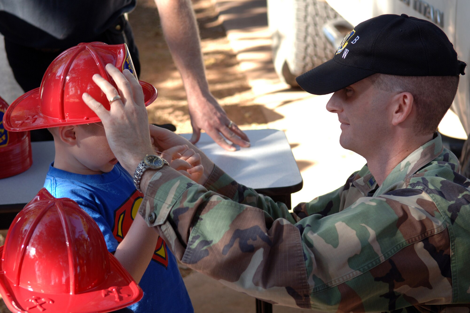 DYESS AIR FORCE BASE, Texas-- Capt. Brad Hickey puts a plastic fire helmet on his son, Andrew (4), during an escape demonstration for fire prevention and safety week, Oct. 9. Fire prevention and safety week is a week long event that takes place all over the base to help children form escape plans and be aware of fire prevention. (U.S. Air Force Photo by Airman 1st Class Micheal Breaux)