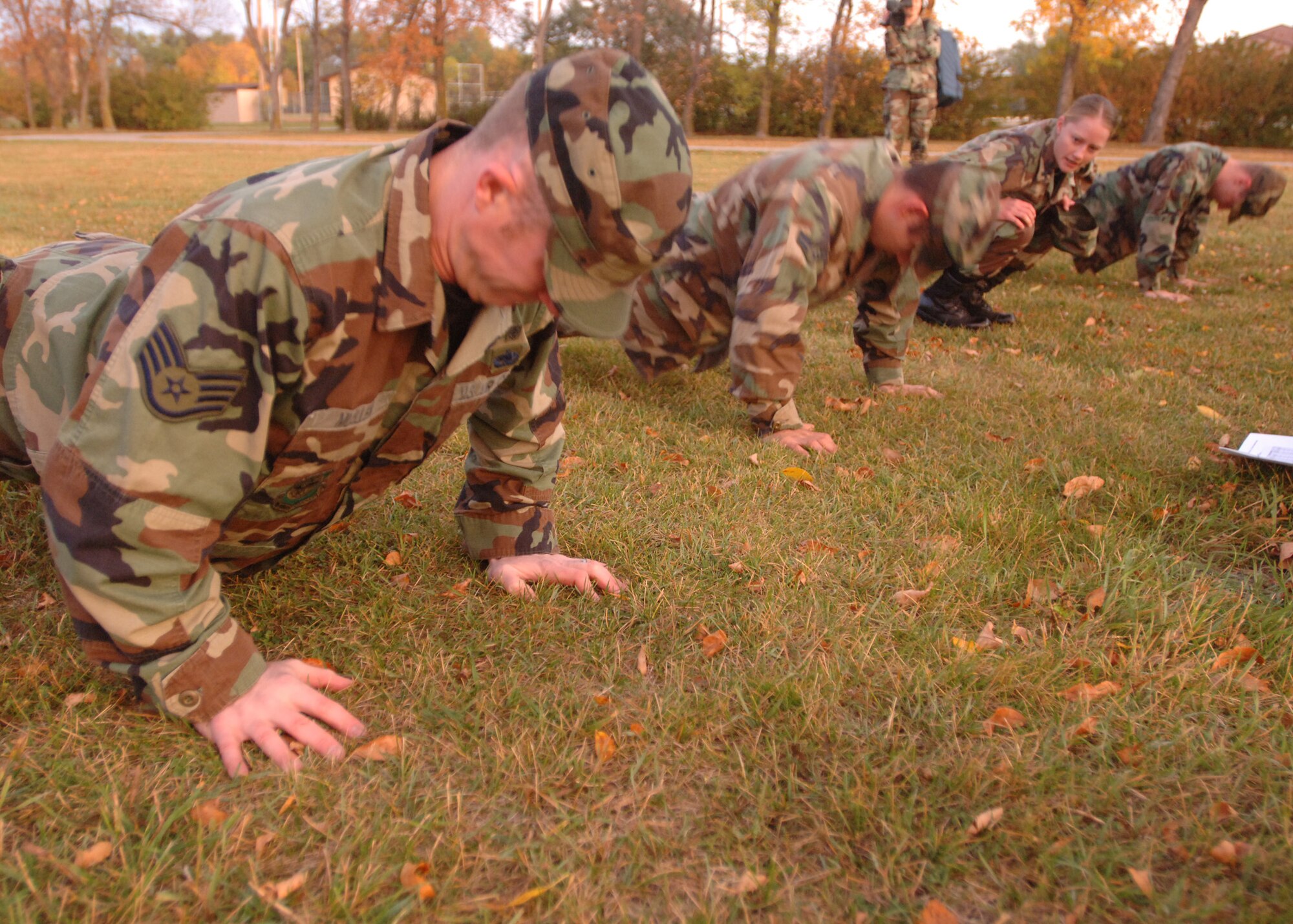 1st Lt. Kaelin Armstrong, 319th Aeromedical Dental Squadron, cheers on her fellow squadron teammates during the push-up part of the Warrior Day Challenge here Sept.28. The Warrior Day Challenge tested Airmen of Grand Forks AFB on their combat readiness through a series of strenuous events including the Air Force physical fitness test, donning Mission Oriented Protective Postures, self aid and buddy care, firearm assembly and knowledge of the Airman's Manual.  (U.S. Air Force photo/Airman 1st Class Chad M. Kellum)