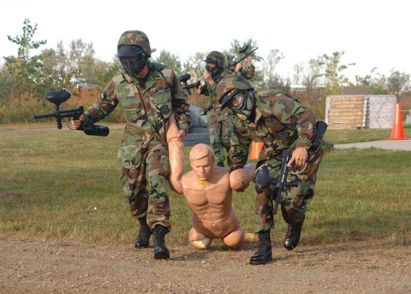 Warriors from 319th Aircraft Maintenance Squadron rescue a casualty and fend off combatants during the Warrior Day Challenge here Sept.28. The Warrior Day Challenge tested Airmen of Grand Forks AFB on their combat readiness through a series of strenuous events including the Air Force physical fitness test, donning Mission Oriented Protective Postures, self aid and buddy care, firearm assembly and knowledge of the Airman's Manual.  (U.S. Air Force photo/Airman 1st Class Chad M. Kellum)