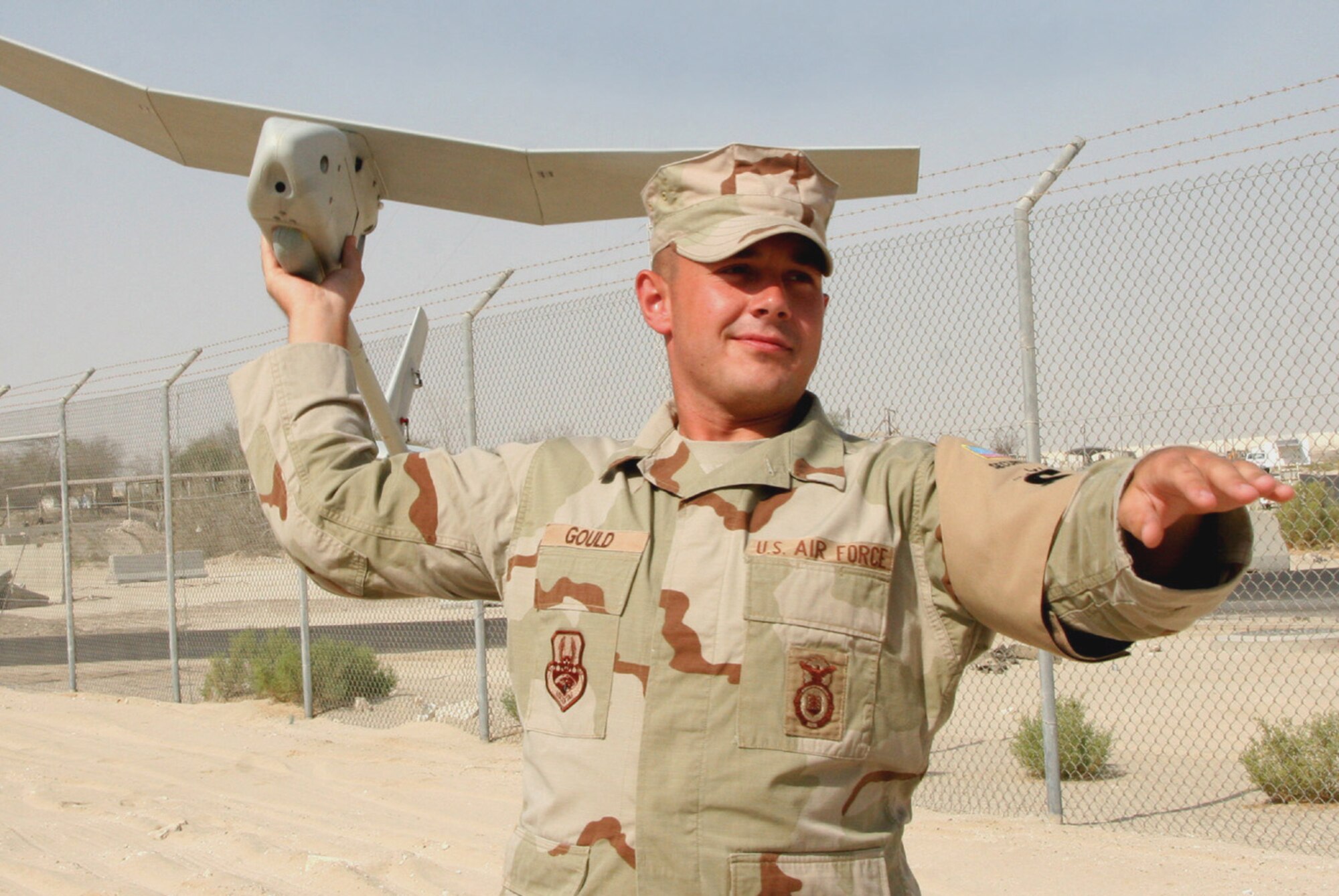 Airman 1st Class James Gould, a certified Raven B operator from the 380th Expeditionary Security Forces Squadron, demonstrates how the Raven B is hand launched for its missions.  (U.S. Air Force Photo/Master Sgt. Ruby Zarzyczny)