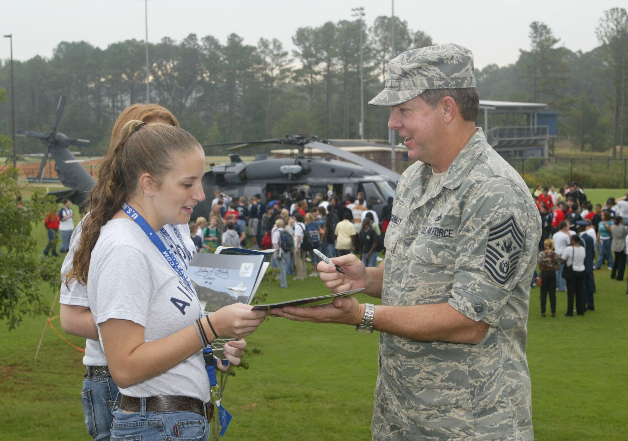 Chief Master Sgt. of the Air Force Rodney J. McKinley autographs brochure for East Paulding High School Air Force JROTC cadet during the "High School Drop-In" event during Air Force Week Atlanta, Oct. 8-14.  The event, staged for high school youth at Marietta High School is highlighted by a helicopter pararescue demonstration performed by the 301st Rescue Squadron, Patrick AFB, Fla. The aircraft used in the demonstration is the HH-60 Pavehawk. (U.S. Air Force photo/Don Peek)