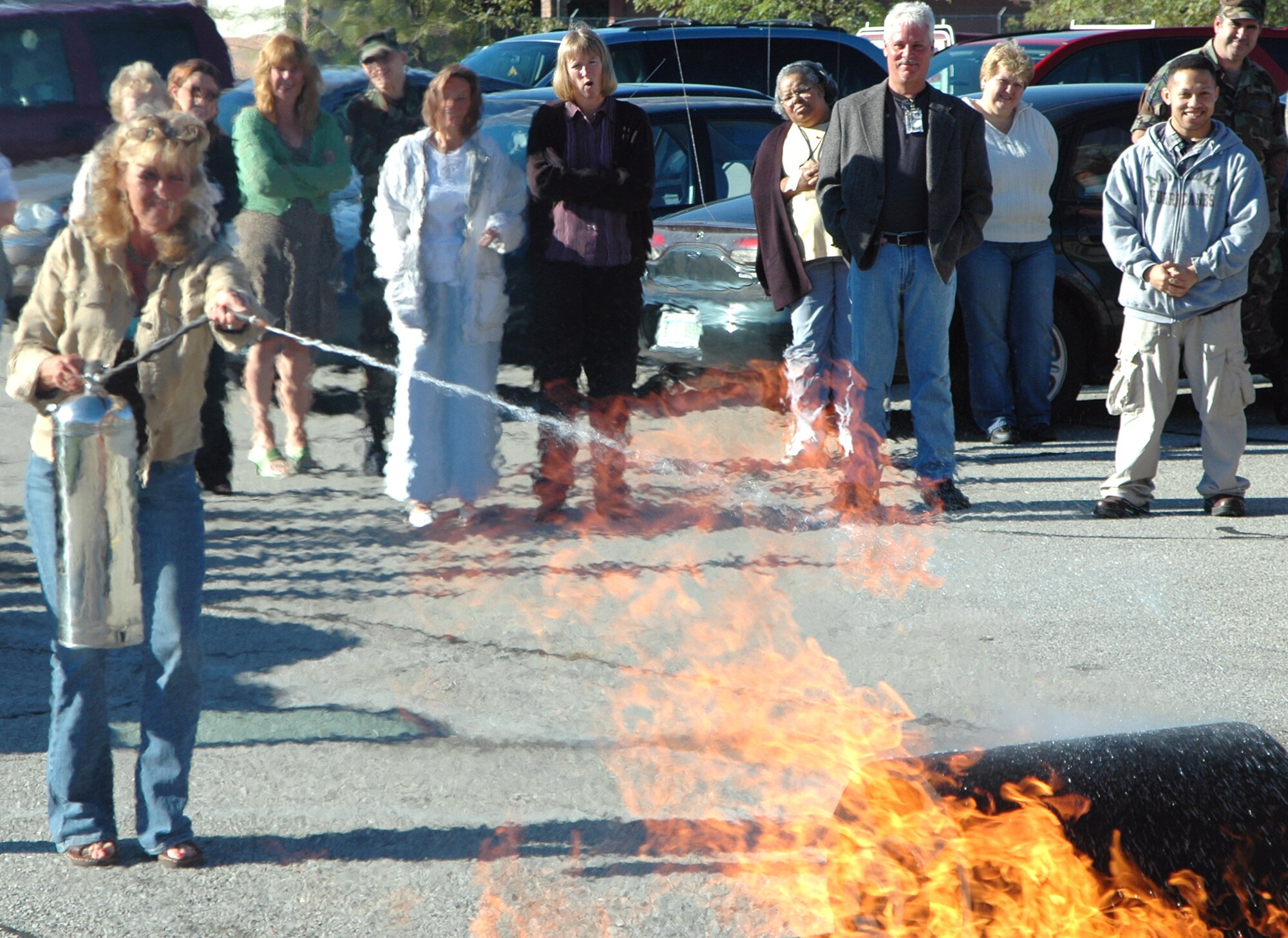 GRISSOM AIR RESERVE BASE, Ind., -- Sue Correll, military pay technician for the 434th Air Refueling Wing, battles the flames and the heat during fire extinguisher training held here Tuesday. The Grissom Fire Department instructed a class as part of fire prevention week activities. (U.S. Air Force photo/ SrA Carl Berry) 