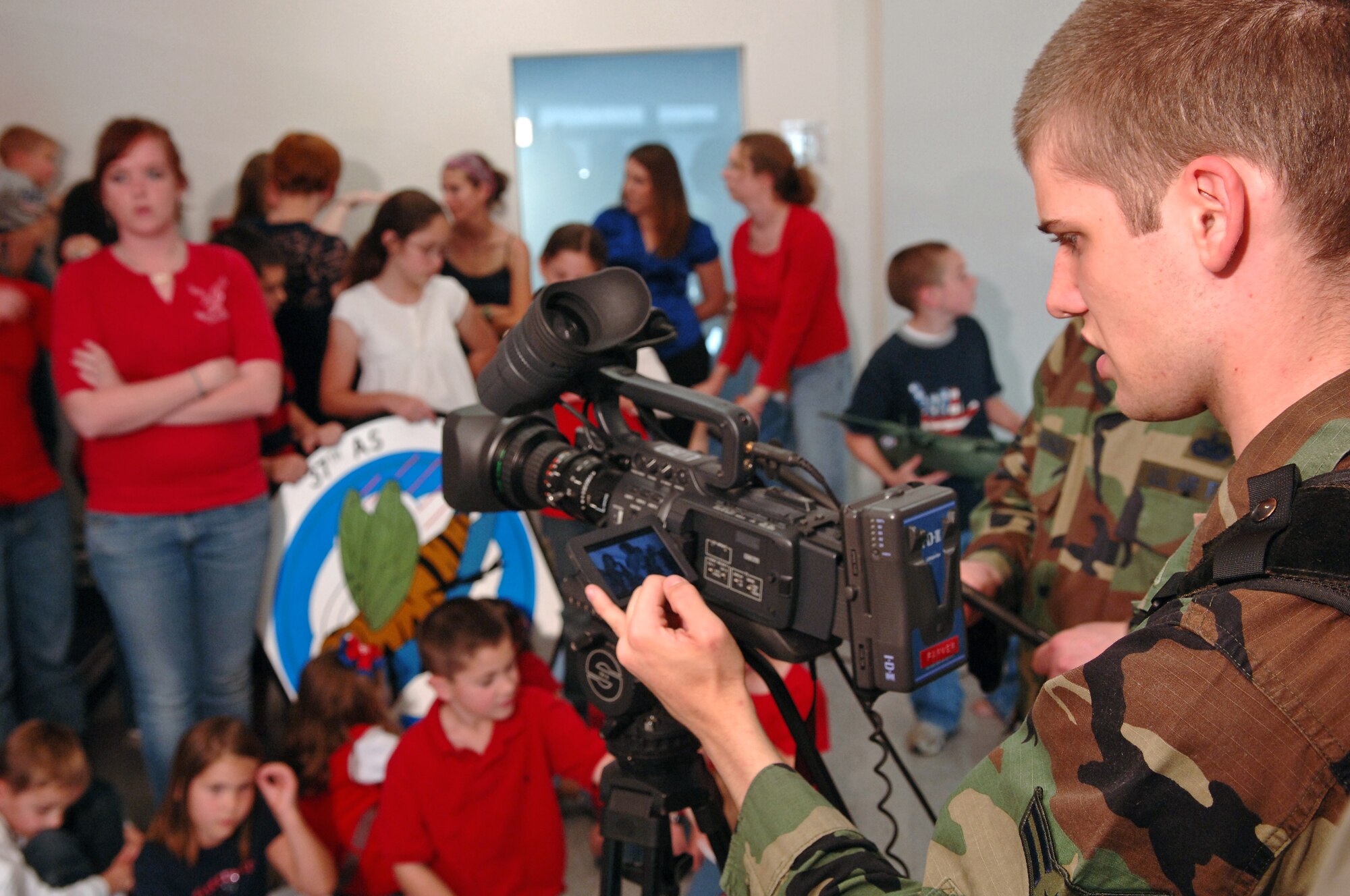 Airman 1st Class Alex Farver, 435th Air Base Wing public affairs videographer, records a video message from the spouses and children of deployed members of the 37th Airlift Squadron on Ramstein Air Base, Germany, Oct. 4. (U.S. Air Force photo/Airman 1st Class Marc I. Lane)