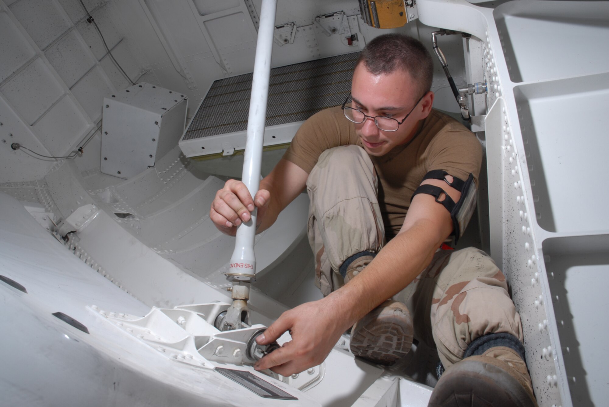 SOUTHWEST ASIA -- Senior Airman Mark A. Mano, 8th Expeditionary Air Mobility Squadron, inspects the nose gear door pin assembly of a C-17 Globemaster here Oct. 8. Airman Mano is deployed from Charleston Air Force Base, S.C. (U.S. Air Force photo/Staff Sergeant Douglas Olsen)