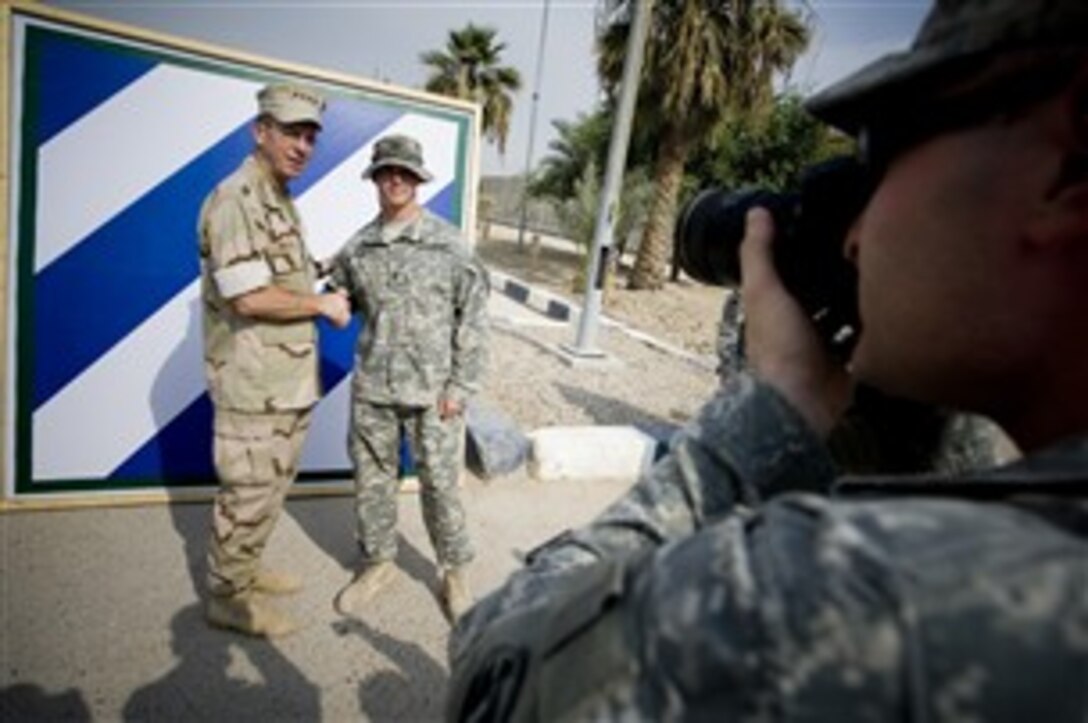 Chairman of the Joint Chiefs of Staff U.S. Navy Adm. Mike Mullen poses with one of the 31 soldiers of the 3rd Infantry Division that he re-enlisted during a ceremony on Camp Victory, Iraq, Oct. 5, 2007.   