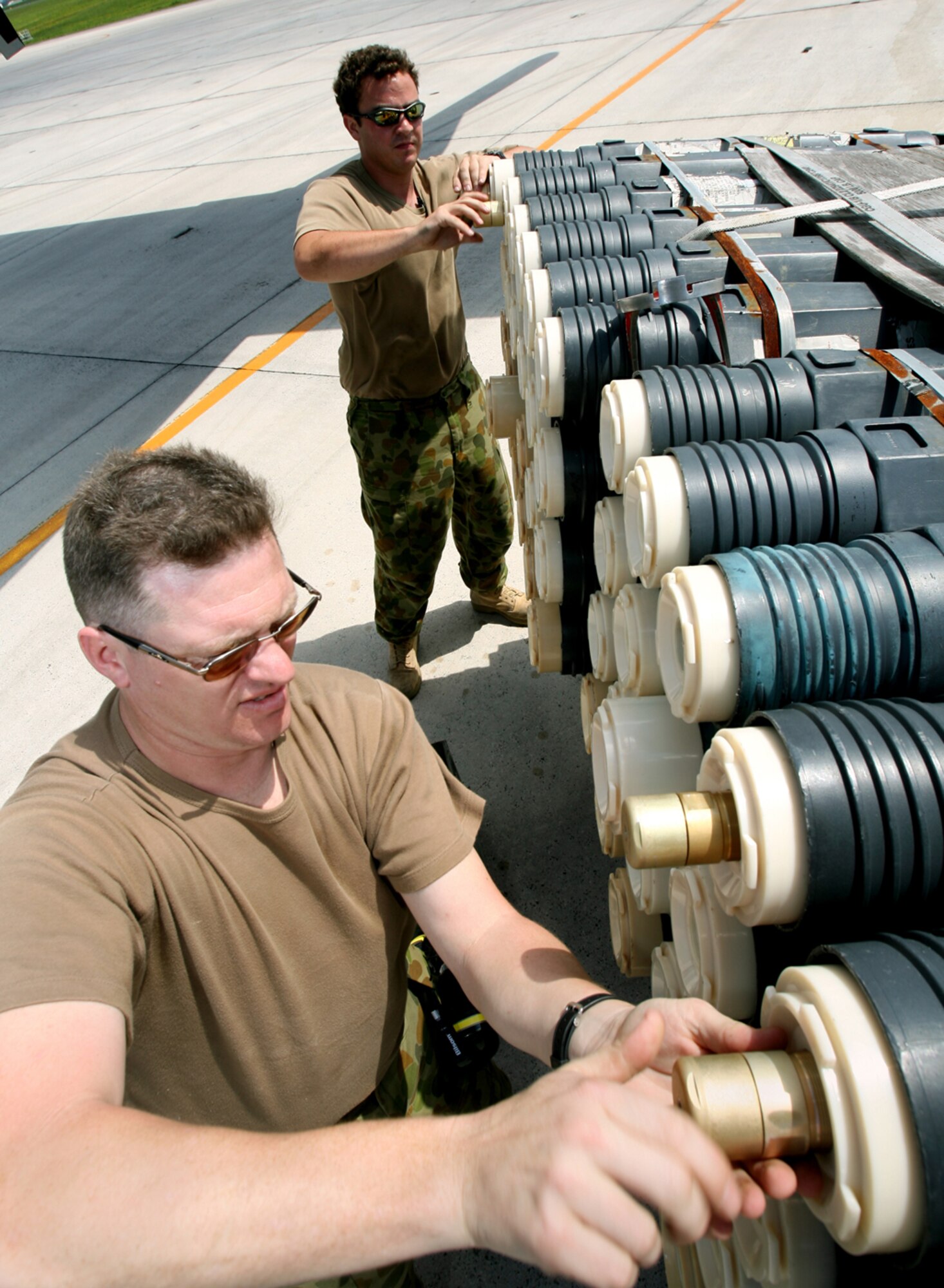 Corporal Daryll Totaro, front, and Leading Aircraftman Adrian Bradley screw "CADS" onto a load of sonobuoys moments before loading them onto 11SQN AP-3C Orion.
Two AP-3C Orions from 11 Squadron, Adelaide, Australia deployed to Kadena AB, Japan, to participate in a multi-lateral maritime patrol and reconnaissance operation in the West Pacific Ocean, Oct. 8–19. The 11 Squadron crews practiced combined anti-ship and anti-submarine warfare operations with the United States Navy under the United Nations Command (Rear) Status of Forces Agreement with the government of Japan. The operation aimed to promote regional security and interoperability between participating nations. (Royal Australian Air Force photo/CPL Eddie Andrew)







