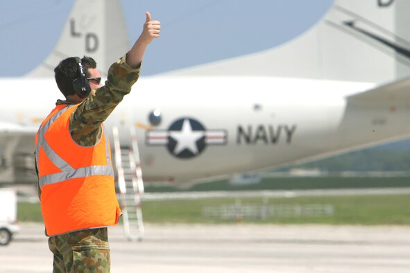 Leading Aircraftman Matt Perkins, 11 Squadron ground crew member, marshalls an AP-3C Orion into position on the Kadena flightline amongst US Navy P-3`s Oct.3.
Two AP-3C Orions from 11 Squadron, Adelaide, Australia deployed to Kadena AB, Japan, to participate in a multi-lateral maritime patrol and reconnaissance operation in the West Pacific Ocean, Oct. 8–19. The 11 Squadron crews practiced combined anti-ship and anti-submarine warfare operations with the United States Navy under the United Nations Command (Rear) Status of Forces Agreement with the government of Japan. The operation aimed to promote regional security and interoperability between participating nations. (Royal Australian Air Force photo/CPL Eddie Andrew)







