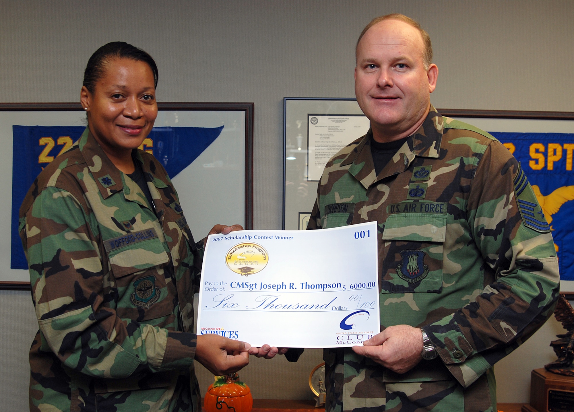Lt. Col. Sonya Collins, 22nd Services Squadron commander presents a $6,000 check to Chief Master Sgt. Joseph Thompson, former 22nd Civil Engineer Squadron chief, Oct. 4, for his first place entry essay in the Air Force wide 2007 Air Force Services Agency Club Scholarship Program. (photo by Airman 1st Class Jessica Lockoski)