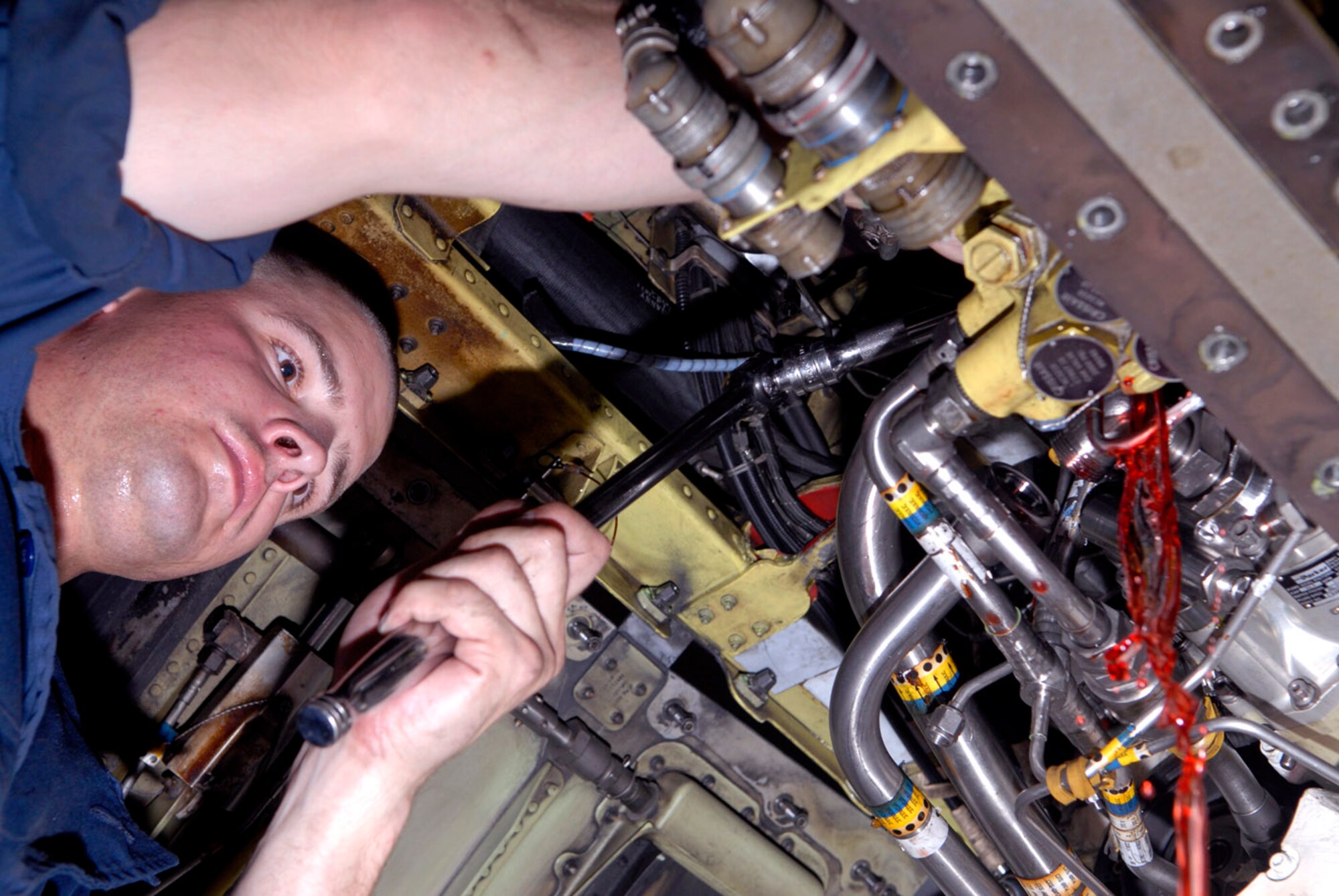 Hydraulic fluid pours out as Senior Airman Christopher Schulte disconnects a hydraulic pump from an F-16 fighting Falcon at Balad Air Base, Iraq, Oct. 10. The hydraulic pump is one of two hydraulic systems that pressurize all hydraulic fluids in the aircraft. Airman Schulte is assigned to the 332nd Expeditionary Maintenance Squadron. (U.S. Air Force photo/Staff Sgt. Joshua Garcia) 
