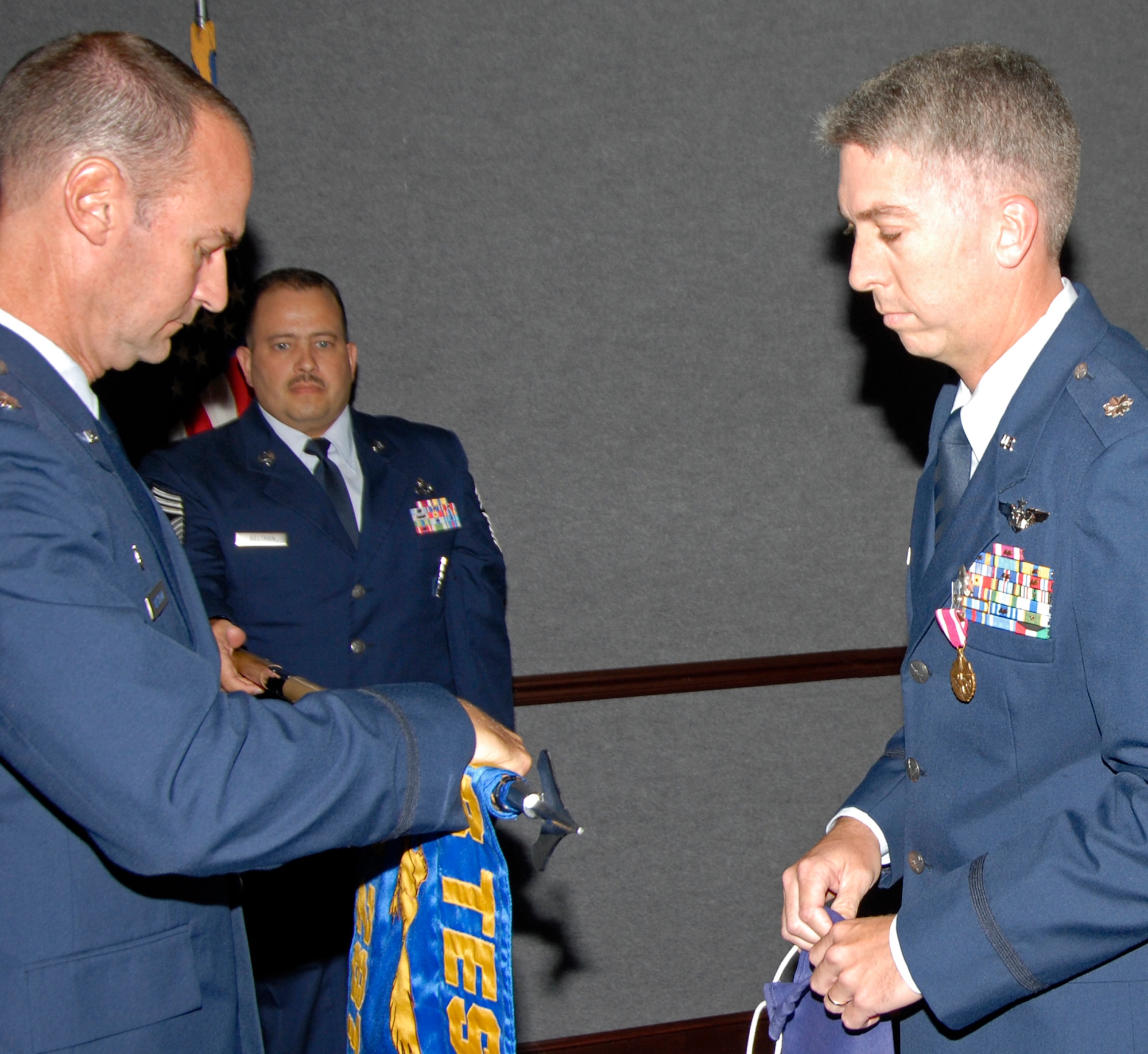 Lt. Col. Henri Castelain, 28th Test and Evaluation Squadron commander, rolls up the flag of Detachment 2 while Lt. Col. Collin Smith, Detachment 2 commander, waits to put the cover over it during the inactivation ceremony Sept. 26 at Tyndall Air Force Base, Fla.  The 28th TES Det. 2 had 32 people assigned to the detachment.  The detachment conducted testing on programs such as F-35, AIM-9X, F-15 Operation Flight Program, ALQ-188 Electronic Warfare Pod, and MC-130 ALQ-69A Radar Warning Receiver.  The original unit, the 4750th Test Squadron, was activated Sept 1, 1956.  The inactivation will save the 53d Wing nearly $350,000 a year.  Air Force photo by Isaac Gibson.